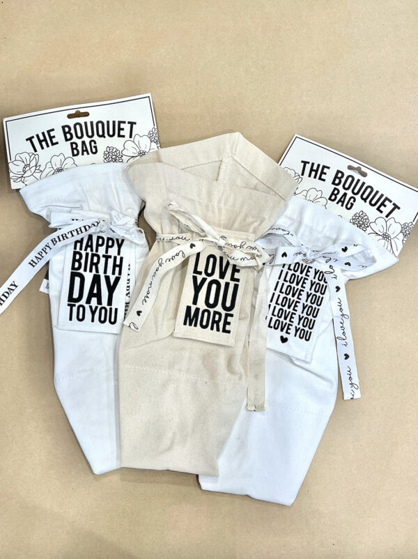special occasion bouquet bags that say "happy birthday to you" and "love you more"